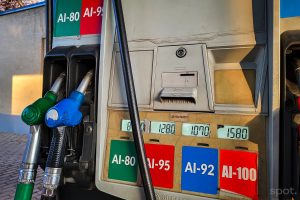 Gas pump at a station showing four fuel options: AI-80 (green), AI-95 (red), AI-92 (blue), and AI-100 (red) with corresponding nozzle hoses and digital price panels above.