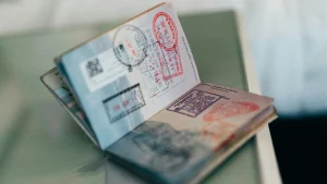 Open passport with multiple visa stamps on two pages, lying on a table at an angle.