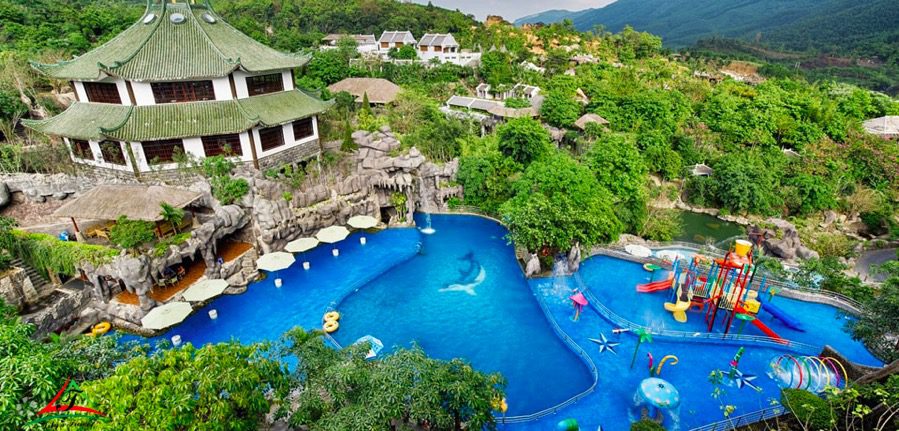 A hillside water park with a bright blue pool, a Chinese-style multi-tier pavilion on the left, rock formations, and a colorful children's play area with slides and tubes.