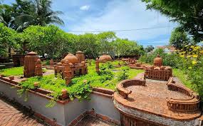 Brick garden with multiple ornamental brick sculptures and raised planters in a sunny yard.