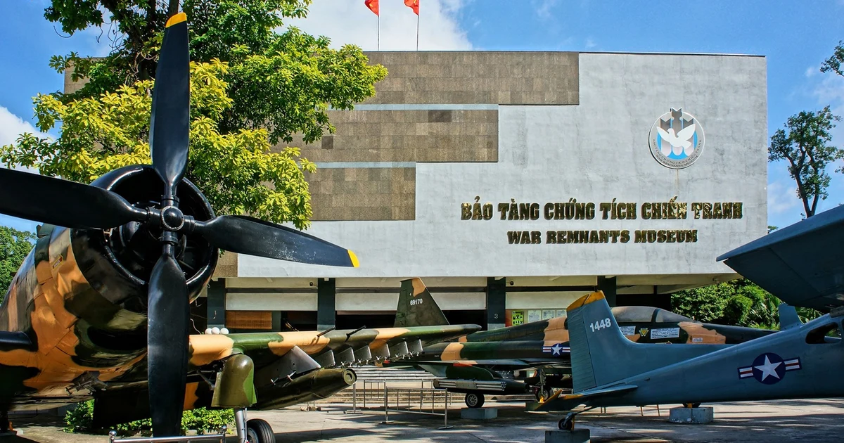Front view of the War Remnants Museum with vintage military aircraft parked outside and a large propeller in the foreground.