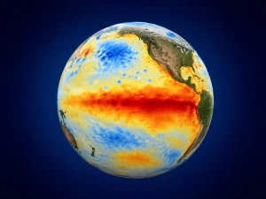 Earth viewed from space showing sea surface temperature anomalies in red/orange for warmth and blue for coolness against a dark blue backdrop.